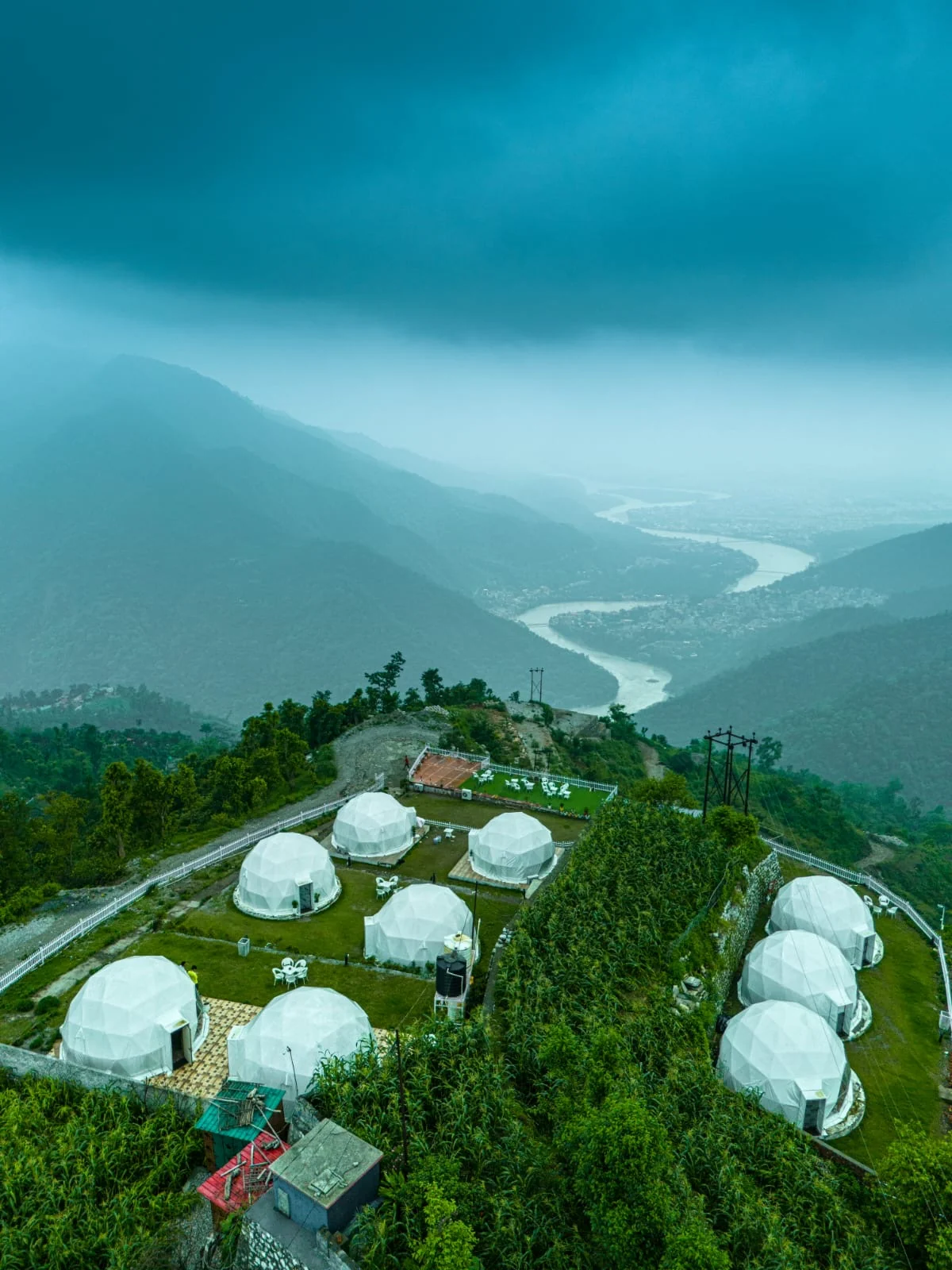 Amantra domes on the hillside overlooking the river and mountains